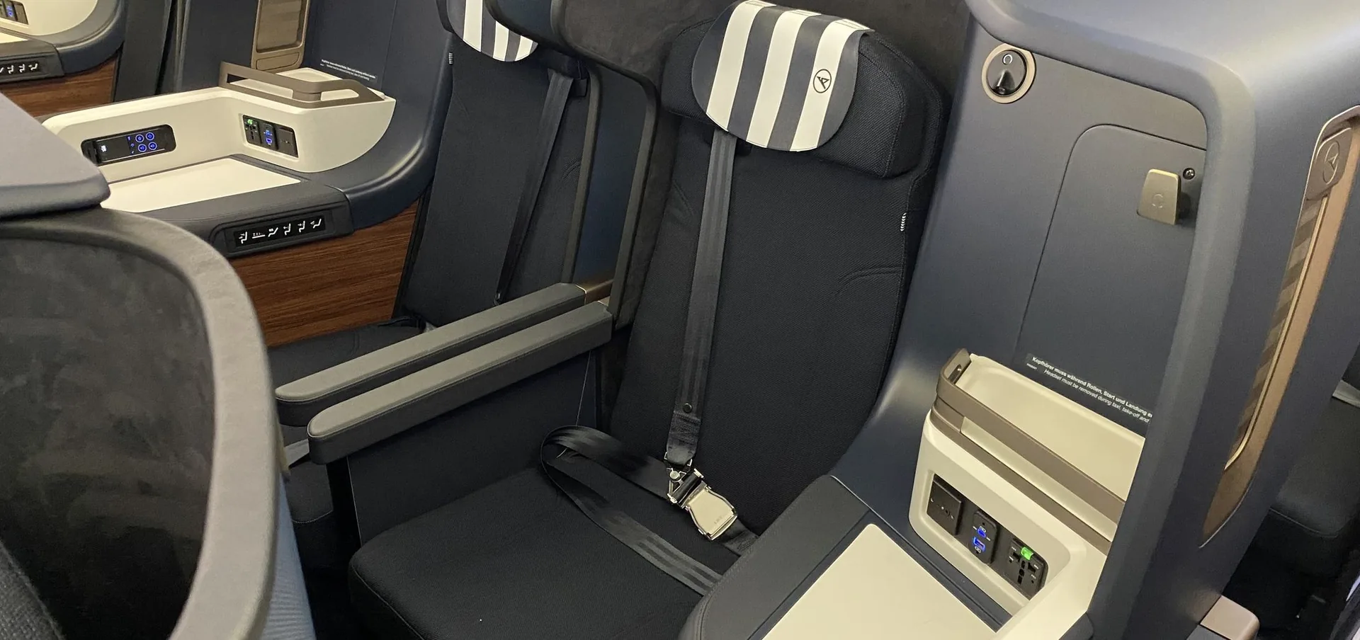 Business class seat and monument in an aircraft cabin