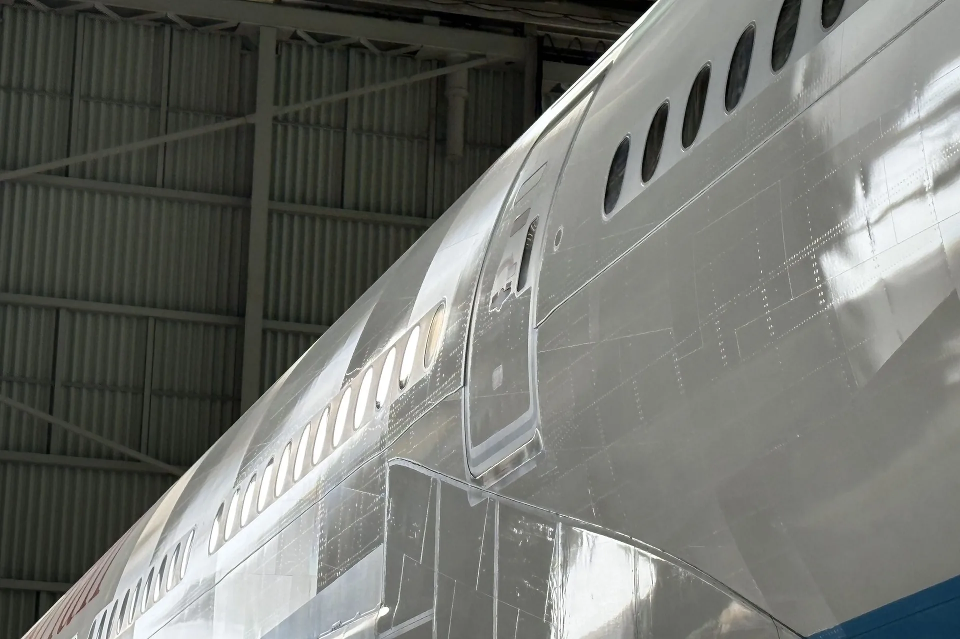 Close-up of a widebody fuselage carrying the AeroSHARK riblet surface in the hangar