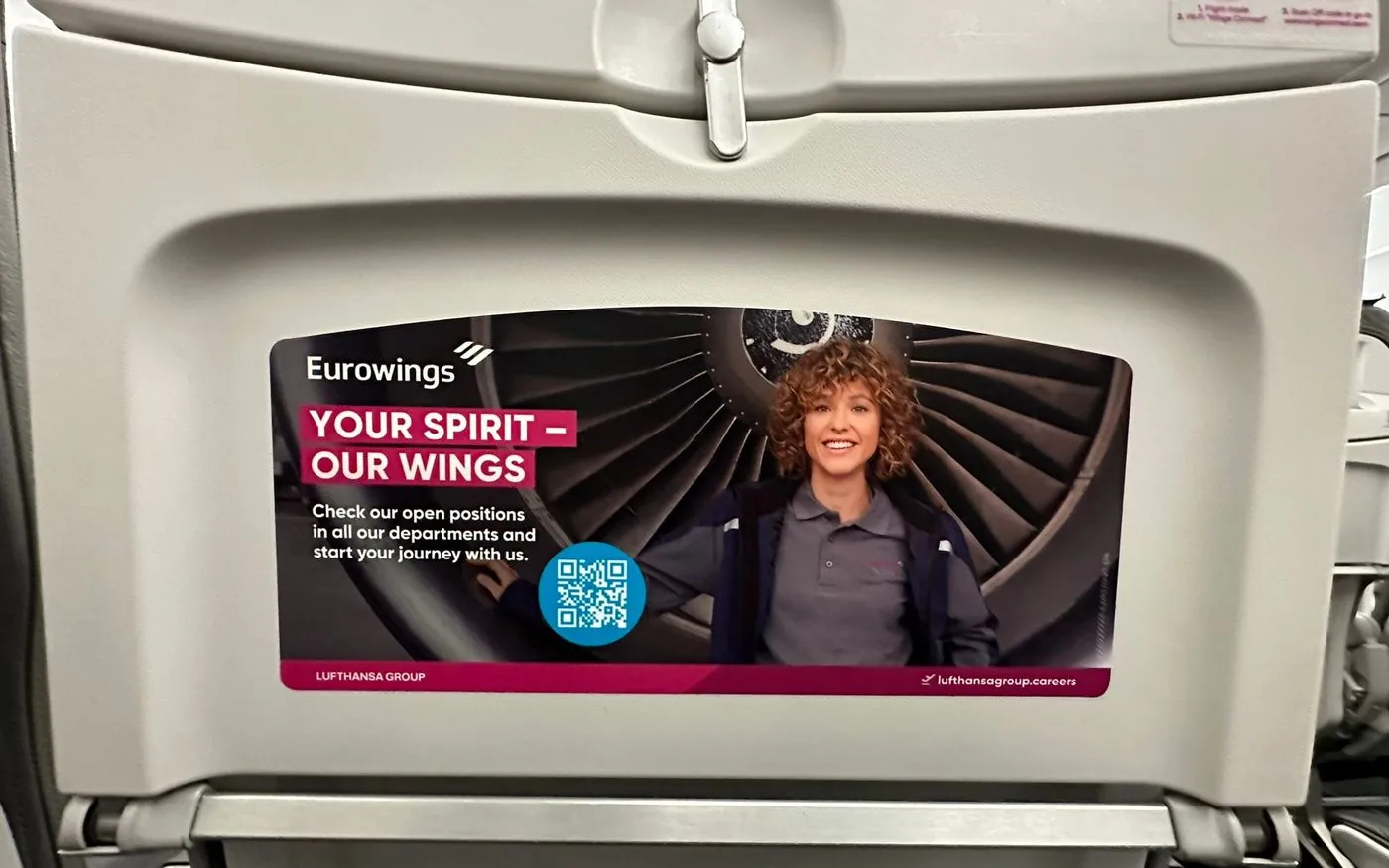 Eurowings employer branding panel on a tray table, with open positions and a QR code