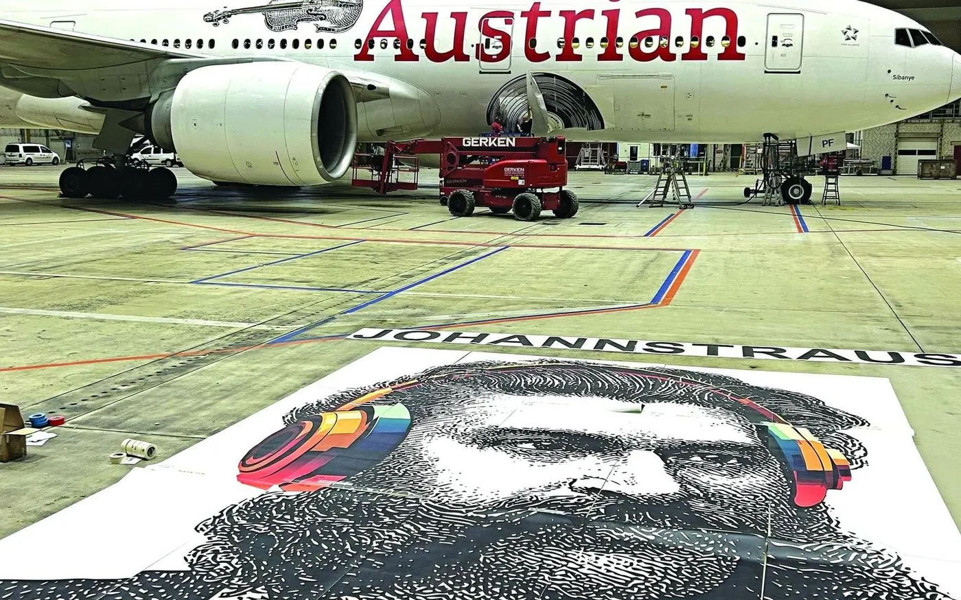 Printed Johann Strauss livery vinyl laid out in front of the Austrian Airlines Boeing 777