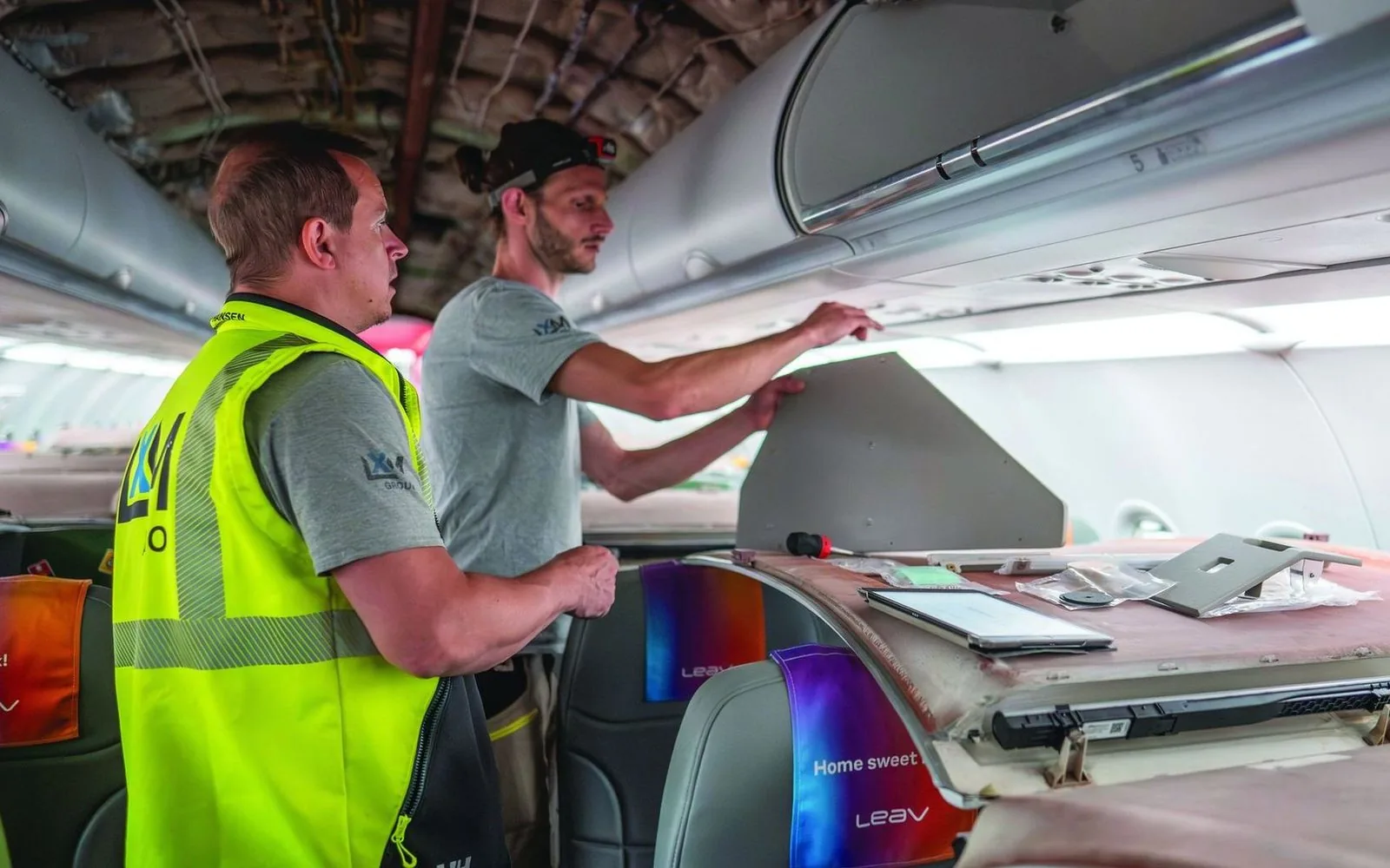 Technicians at an open overhead bin during an IFE installation