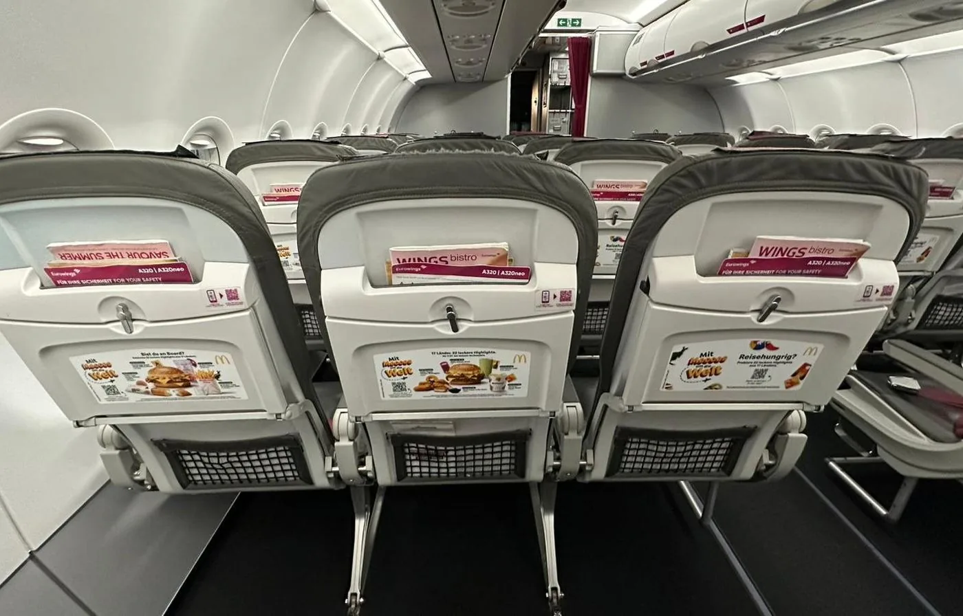 Three cabin seats with campaign graphics on the tray tables