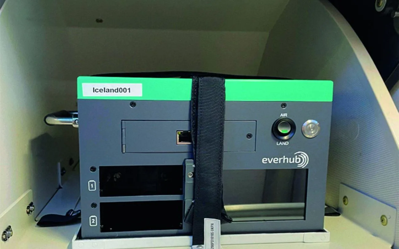 Wireless IFE server unit held in an overhead bin by a restraining strap